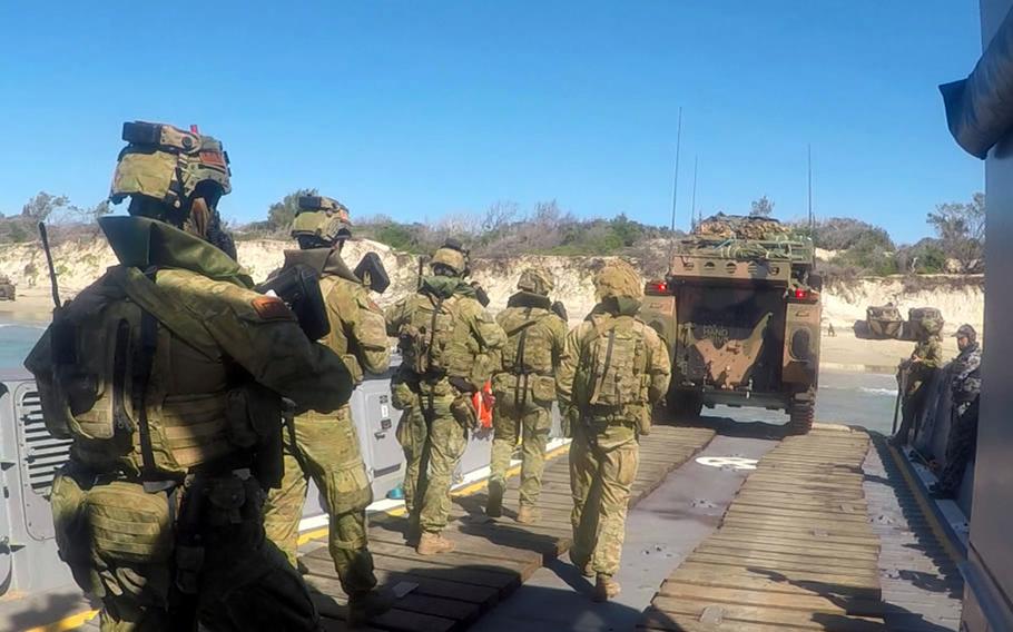 Australian soldiers disembark a landing transport vehicle for an amphibious assault on a beach in northeastern Australia, Tuesday, July 16, 2019. A light armored vehicle leads the way.