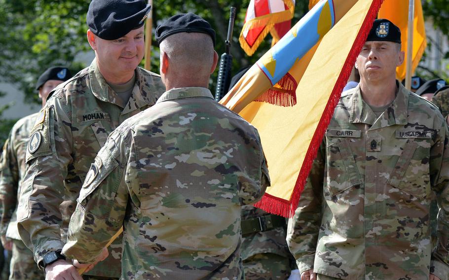 The incoming commander of the 21st Theater Sustainment Command, Maj. Gen. Christopher O. Mohan, takes the unit's guidon from Lt. Gen. Christopher G. Cavoli, U.S. Army Europe commander, at the 21st TSC change of command ceremony in Kaiserslautern, Germany, Wednesday, July 31, 2019. Mohan replaced Maj. Gen. Steven A. Shapiro as commander. At right is Command Sgt. Maj. Rocky L. Carr.