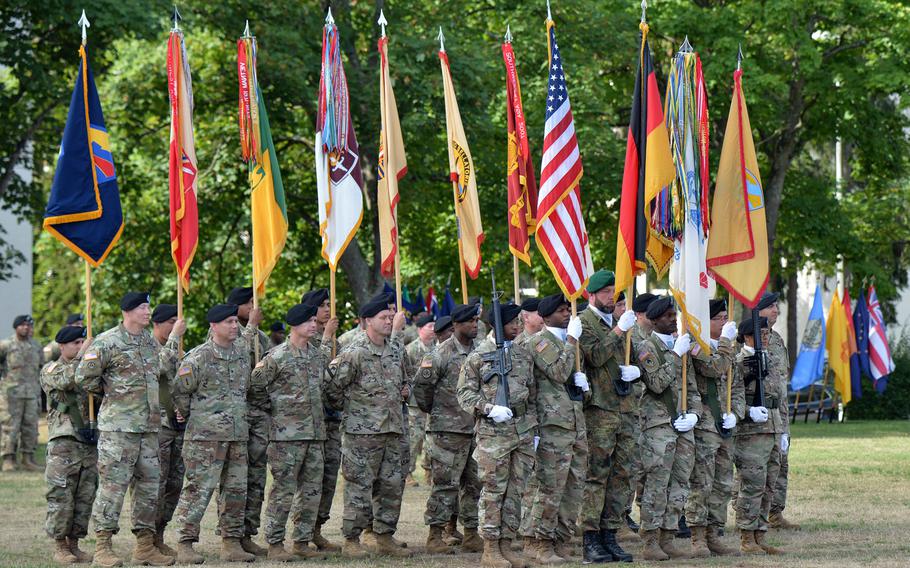 The 21st Theater Sustainment Command color guard and soldiers with unit colors stand on the Daenner Kaserne parade field during the 21st Theater Sustainment Command change of command ceremony in Kaiserslautern, Germany, Wednesday, July 31, 2019.