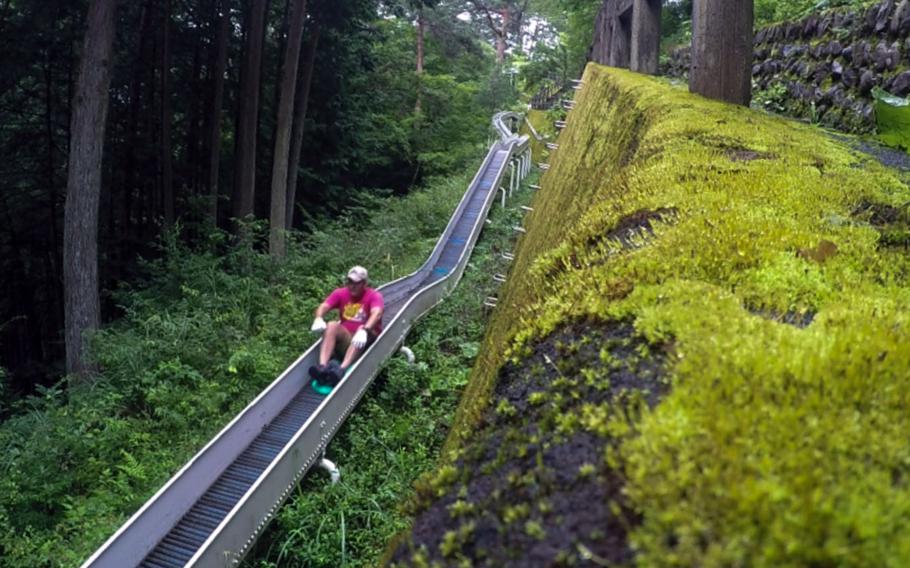 A rider picks up speed as he hits the steeper parts of Japan's longest roller slide in the village of Tabayama.