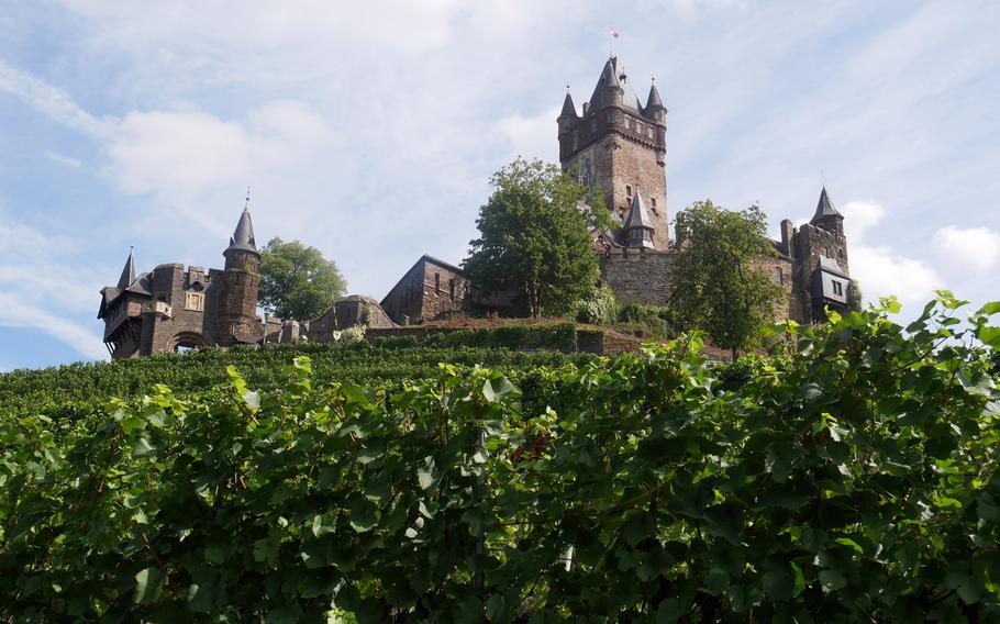 Vineyards lead up to Reichsburg Cochem on the Moselle River. Parts of the castle date back to the 11th century and the town is a popular tourist destination.