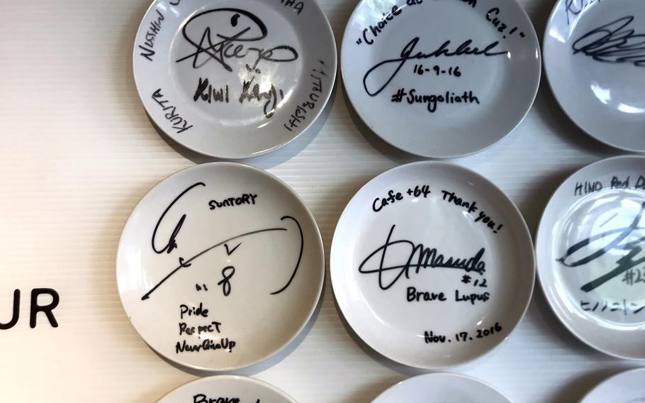 A wall at the+64 Cafe in western Tokyo is decorated with saucers signed by professional rugby players.