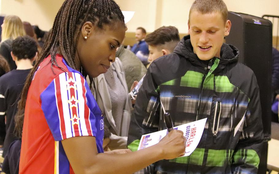 Harlem Globetrotter TNT Lister signs autographs for fans following a game at the Dragon Fitness Center, Aviano Air Base, Italy, Nov. 12, 2019.