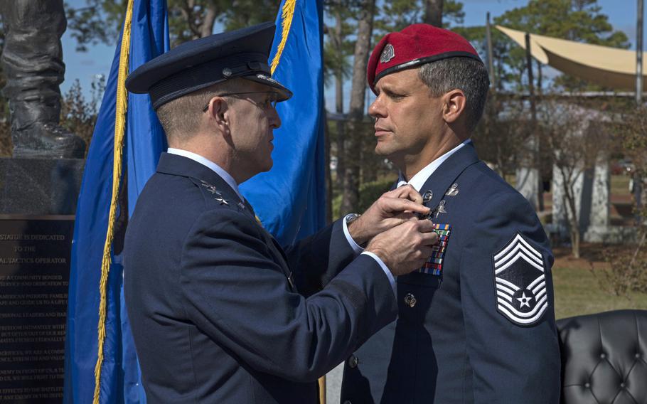 Lt. Gen. Jim Slife, commander of Air Force Special Operations Command, pins the Silver Star medal onto Chief Master Sgt. Chris Grove during a ceremony at Hurlburt Field, Fla., Nov. 15, 2019.