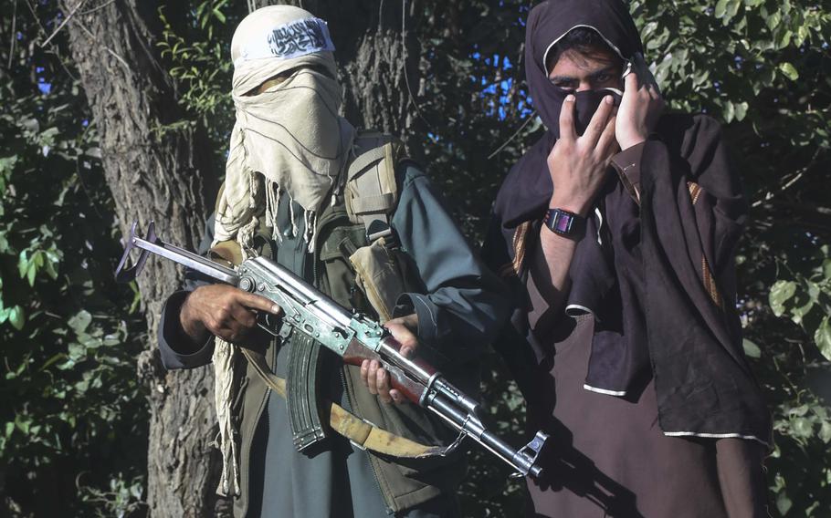 Armed militants watch a convoy pass through Logar province during a cease-fire between the Taliban and the Afghan government in 2018. A new reports says the terror group killed more than 6,000 people last year.