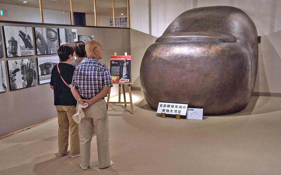 Tourists walk through the interior of the Ushiku Daibutsu, viewing photographs, sculptures and a replica of its toe, Sept. 18, 2019.