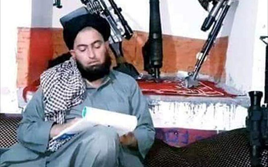 Mullah Nangyalai, a regional leader of the Taliban breakaway faction led by Mullah Mohammad Rasoul, writes on a notepad in an undated photo provided by friends of his. Nangyalai was killed in an airstrike on Jan. 8, 2020 in western Afghanistan, the Rasoul splinter group said.