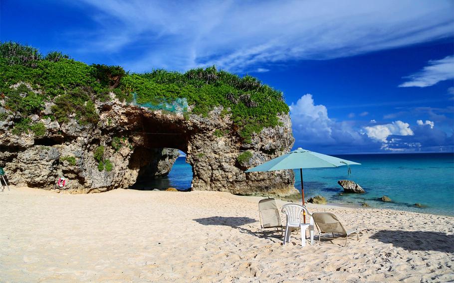 A short tunnel goes through a dome-shaped rock on Sunayama Beach. Many visitors take photos in front of the rock.