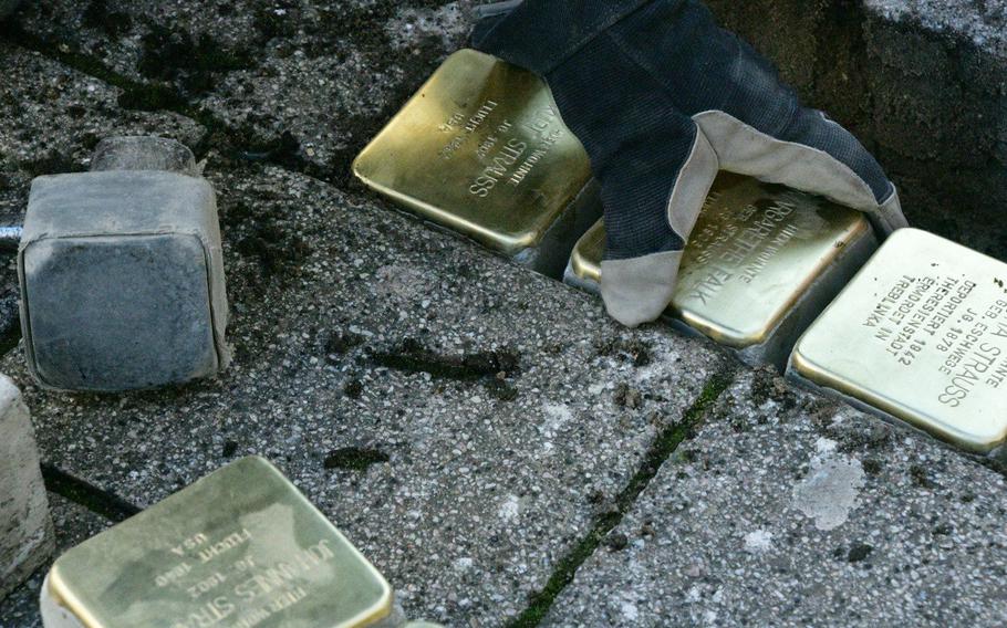 Artist Gunther Demnig places a Stolperstein in a hole in the sidewalk on Eisenbahnstrasse in Kaiserslautern, Germany, on Wednesday, February 5, 2020. The 4 x 4-inch brass squares, which are in 1,200 German cities and towns and 23 European countries, remember victims of Nazi persecution like the Strausses, who were Jewish.