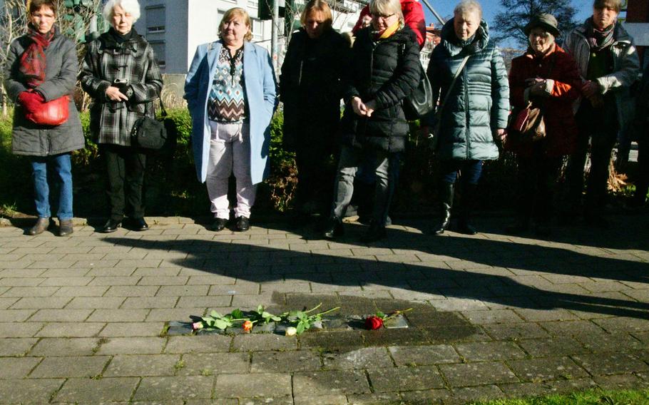 A group of people listen to speeches after a new Stolperstein - small memorials to victims of Germany's World War II Nazi regime - is added to several laid previously at Philipp-Mees-Platz near the police headquarters in Kaiserslautern, Germany, on Wednesday, February 5, 2020. The Stolpersteine laid here honor the memories of political opponents of the Nazis.