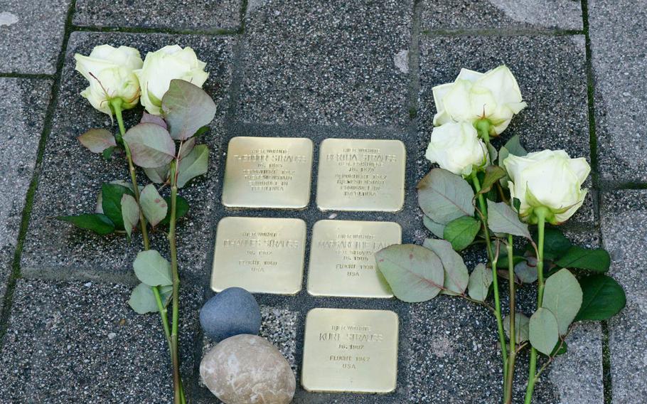 White roses lie by the Stolpersteine laid Wednesday, February 5, 2020 on Eisenbahnstrasse in Kaiserslautern, Germany, memorializing the Strauss family. The parents were deported to Theresienstadt in what is now the Czech Republic and then to Treblinka in Poland, where they were murdered, but the three children fled to the U.S. and survived the Holocaust.