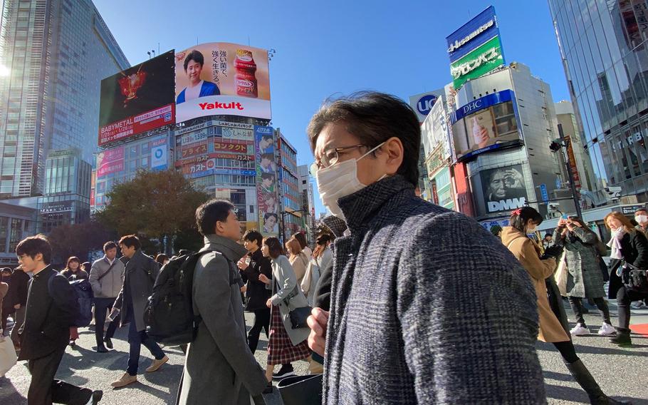 Tokyoites and tourists walk across the popular Shibuya Scramble intersection in central Tokyo in November 2019.
