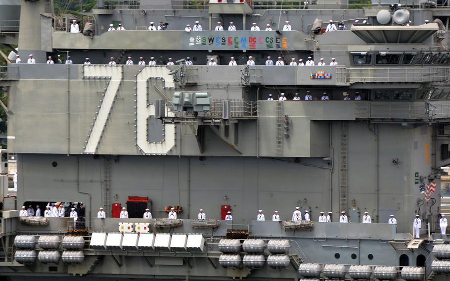 Sailors man the rails of the aircraft carrier USS Ronald Reagan as it departs Yokosuka Naval Base, Japan, in May 2018.