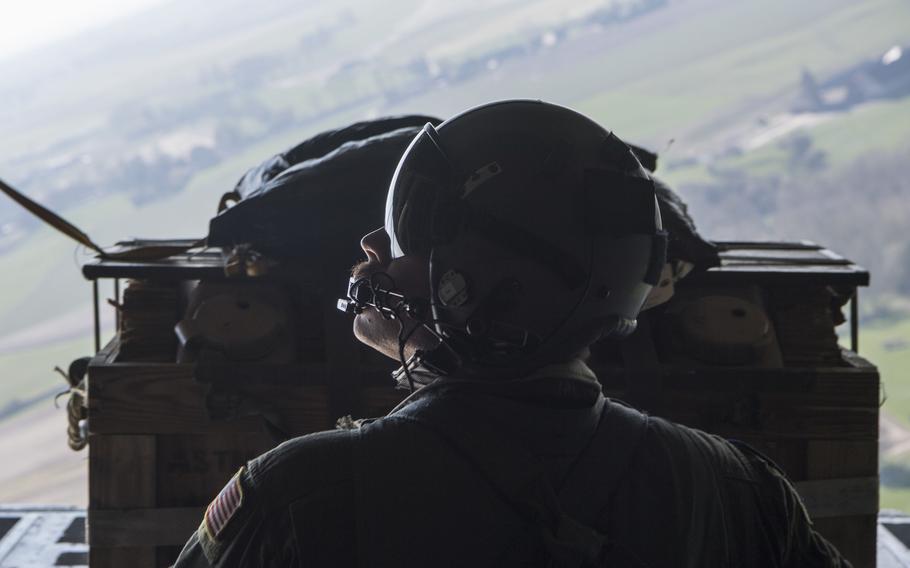 Air Force Tech. Sgt. Alex Carlson, a 37th Airlift Squadron loadmaster, prepares to push an airdrop package out the back of a C-130J Super Hercules aircraft over Chievres Air Base, Belgium, on March 26, 2020.