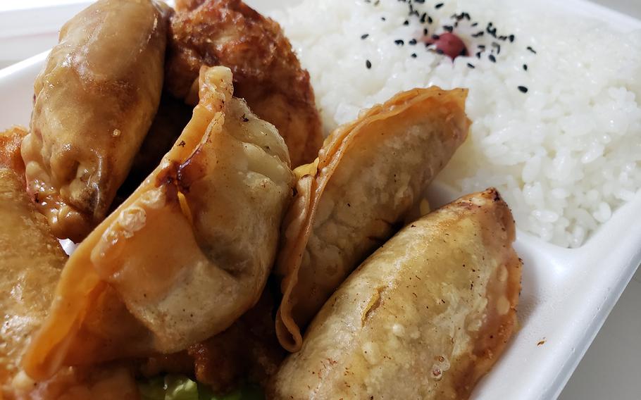 The $5 gyoza bento from Lunch House Turtle, a takeout eatery near Yokota Air Base in western Tokyo, includes five deep-fried pot stickers, sliced fried chicken breast and a large portion of rice.