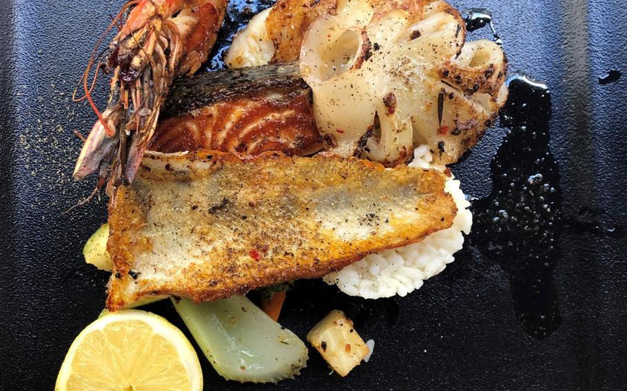 A head-on prawn, calamari, branzino, salmon and a roasted pike perch filet, served with rice and roasted vegetables at La Cantinetta in Wiesbaden, Germany.