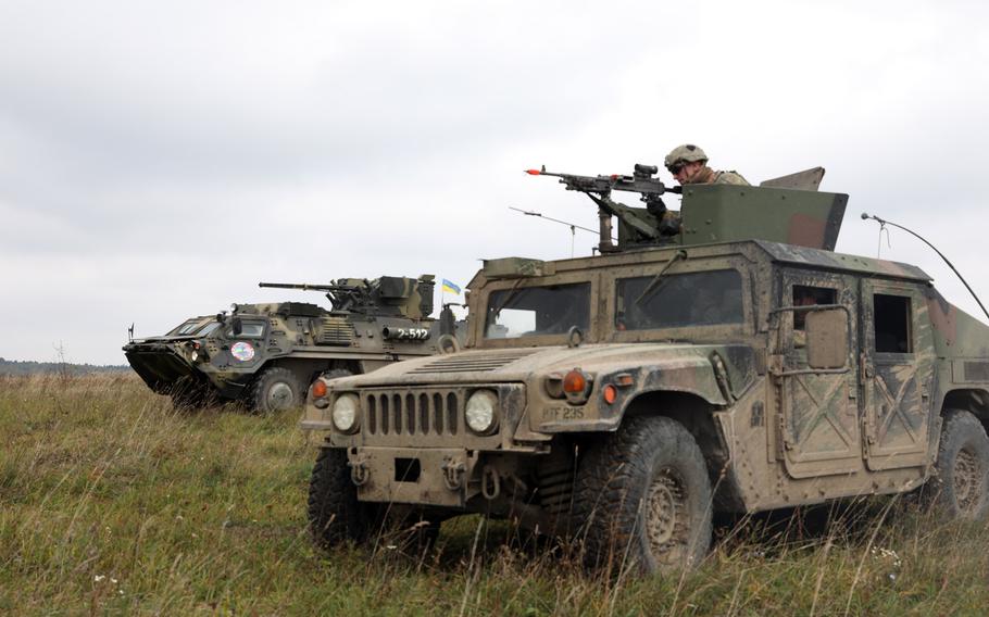 A firing squad from the 101st Airborne Infantry Division, in a Humvee, right, and a Ukrainian armored military vehicle from the 10th Mountain Assault Brigade prepare to engage targets during Rapid Trident 2019 in Yavoriv, Ukraine, Sept. 26, 2019. The Pentagon has earmarked $250 million to aid Ukraine, whose forces are battling Russian-backed separatists. Kyle Larsen/U.S. Army