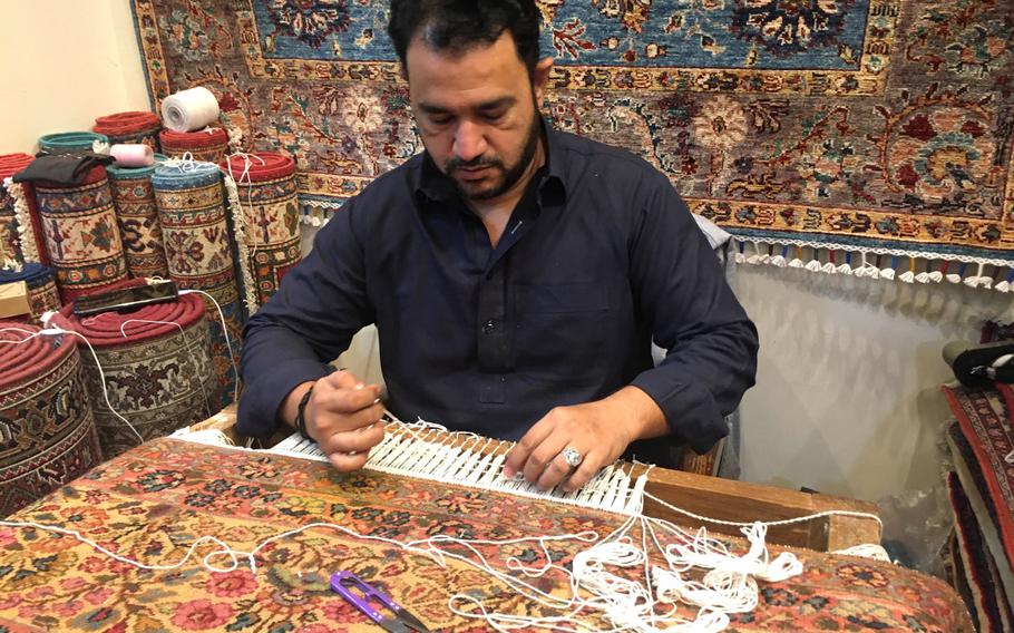 Mustafa Ameen repairs a carpet at the Carpet House in Adliya, Bahrain.