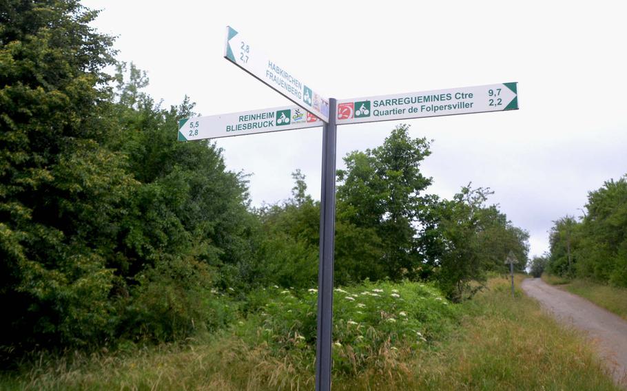 Signs in a village on the border between Germany and France point in different directions, indicating bike paths and where they lead. In some villages, the signs are much smaller and less informative.