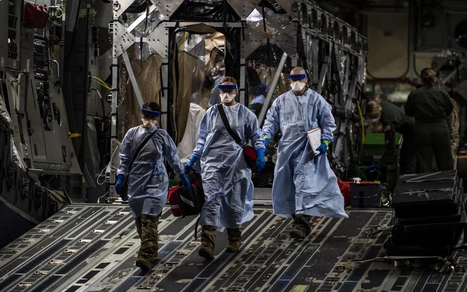 Three medical airmen exit a C-17 Globemaster III aircraft at Ramstein Air Base, Germany, April 10, 2020, following the first-ever operational use of the Transport Isolation System. A new study of active-duty members diagnosed with the coronavirus found that most had mild illness with no complications. 
                