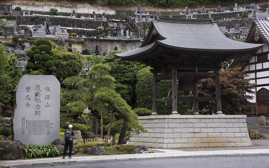 A hiker admires the scenery at Hokoji in Hinode, Japan, Thursday June 25, 2020.