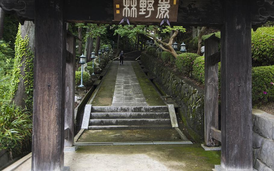 A hiker takes a path lined with sculptures at Hokoji in Hinode, Japan, Thursday June 25, 2020.