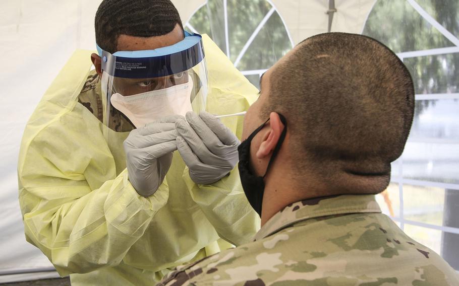 A medic at the clinic in Wiesbaden, Germany swabs a patient for coronavirus testing, June 12, 2020. Public health officials are expanding testing for the virus and screening personnel as they arrive in Europe. Quarantines will be mandatory for new arrivals from high-risk areas regardless of test results, following a spike in the number of infections, military officials said.