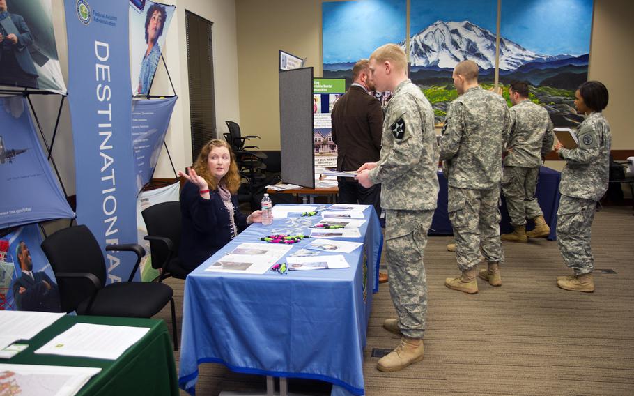 Spc. Andrew Cooper learns about job opportunities at the Federal Aviation Administration desk during a career fair on Feb. 12, 2015. 