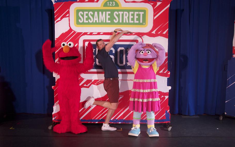"Elmo," actor Justin Gamerl and "Katie" strike a pose on the set of the Sesame Street/USO tour, which is visiting military bases throughout the U.S. In the newest show, "Transitions," Katie's dad is transitioning out of the military and, at first. Katie feels very uncomfortable about this new challenge.