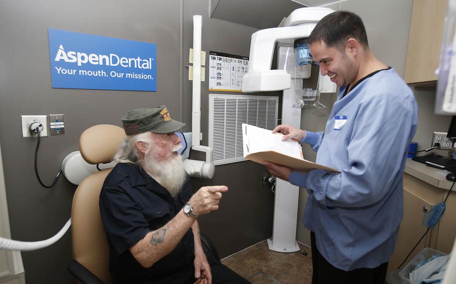 An Aspen Dental volunteer serves Navy veteran John Stinman on the MouthMobile, a 42-foot dental office on wheels, in Phoenix, where this year’s 30-stop tour started.