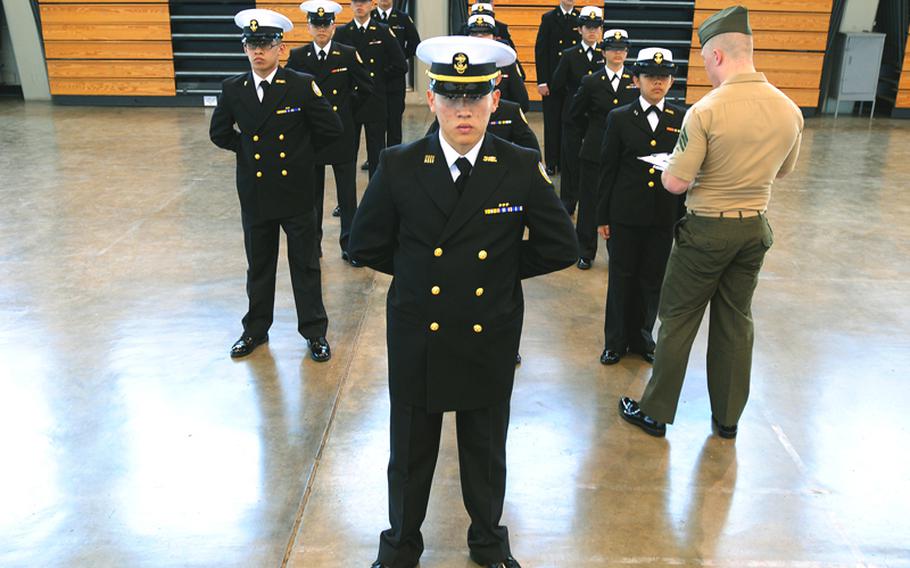 Navy JROTC Patrick Perez from Nile C. Kinnick High School, Yokosuka, Japan, leads his team’s formation during the conclusion of the inspection portion of the Far East Rife and Drill Competition at the Camp Foster Field House. 