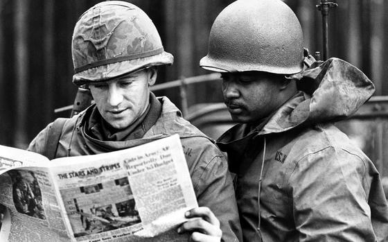 Troops read an issue of Stars and Stripes. Date and location unknown. DATE CREATED 04/18/2017 date of SSE 75th anniversary publication; TRUE date unknown. Date on front could not be read