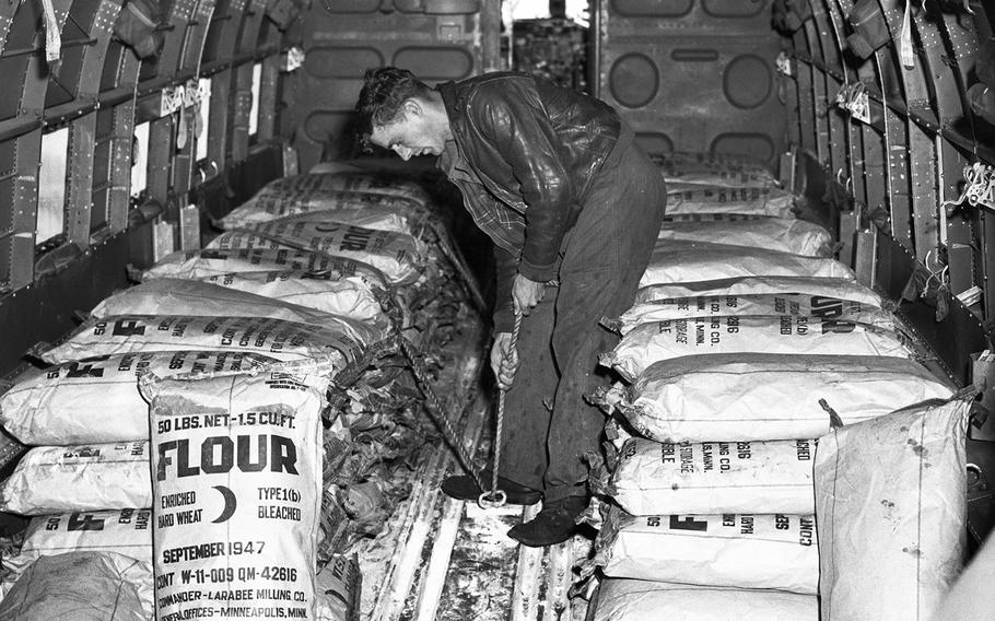 Frankfurt, Germany, June, 1948: A worker at the Rhein-Main airport secures sacks of flour loaded onto a plane for shipment to blockaded Berlin during the first week of the Berlin airlift. 