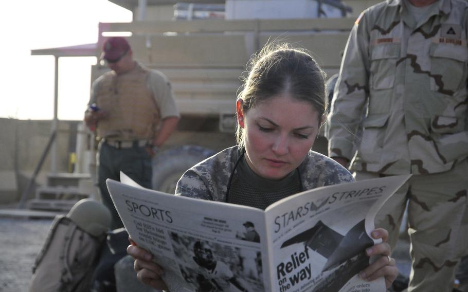 U.S. Army 1st Lt. Tracy Tyson, with 5th Brigade Combat Team, 2nd Infantry Division, reads the Stars and Stripes newspaper at Kandahar Airfield, Afghanistan, Oct. 5, 2009. Tyson is waiting for a flight to Forward Observation Base Wolverine.