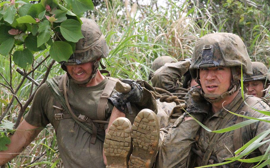 Lance Cpl. Ryan Foret, right, and Lance Cpl. Richard Orozco, strain as they reach the top of a jungle slope carrying a Marine on a stretcher made from branches and uniform tops during the Jungle Warfare Training Center's vaunted E-Course. The Marines from 3rd Platoon, Company I, 3rd Battalion, 2nd Marine Regiment based out of Camp Lejeune are in Japan on a six-month rotational deployment through the Unit Deployment Program. The program was scaled back during the wars in Iraq and Afghanistan but is now being revamped. 
