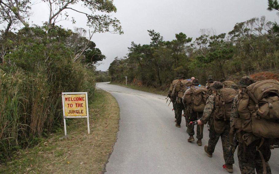 Marines from Company I, 3rd Battalion, 2nd Marine Regiment based out of Camp Lejeune, N.C., march into the jungle under overcast skies at the beginning of jungle warfare training in Okinawa in March 2015.