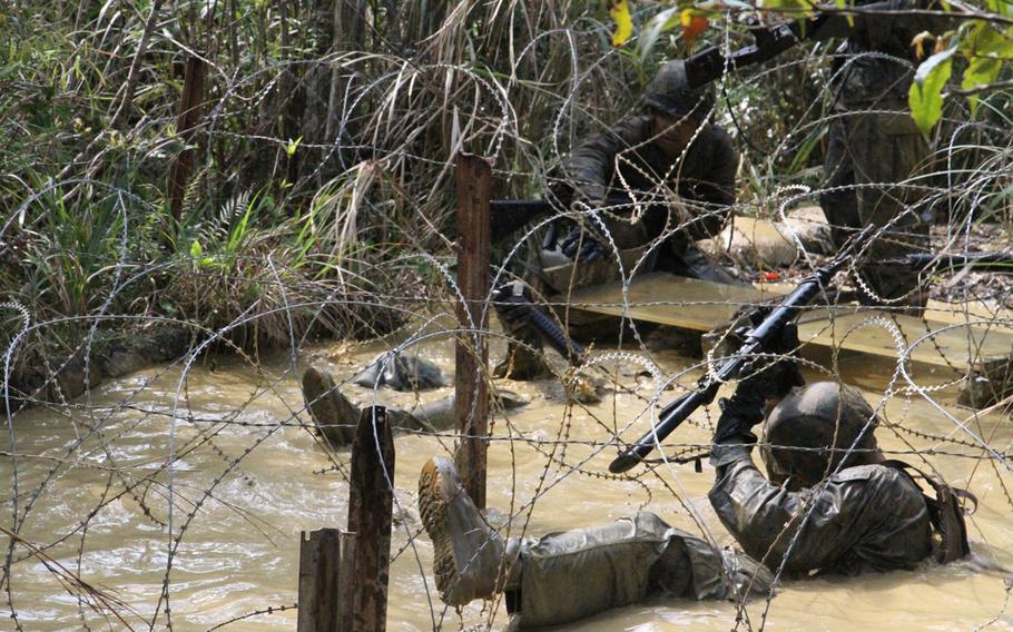 A Marine gets tangled in concertina wire during the E-Course at Okinawa's Jungle Warfare Training Center in March.