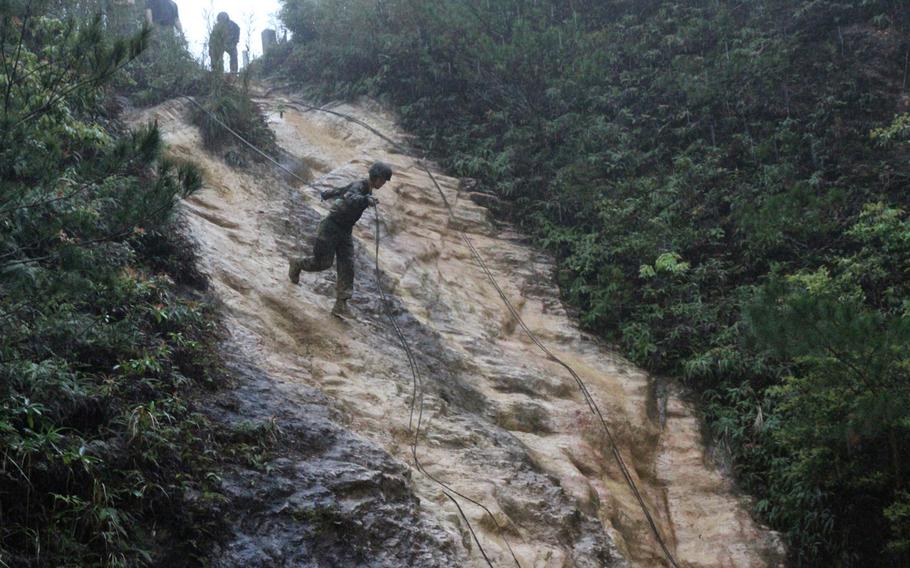 A Marine performs a hasty rappel in the pouring rain at Okinawa's Jungle Warfare Training Center in March 2015. A hasty rappel is essentially running headlong down a steep rockface holding a single strand of rope, without a safety harness.