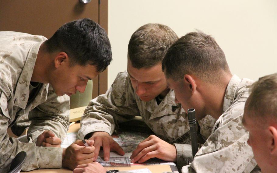Lance Cpl. Andrew Luna, left, watches intently as Cpl. Logan Hampton, center, plots call-for-fire coordinates at the Rodriguez Live Fire Complex in South Korea.