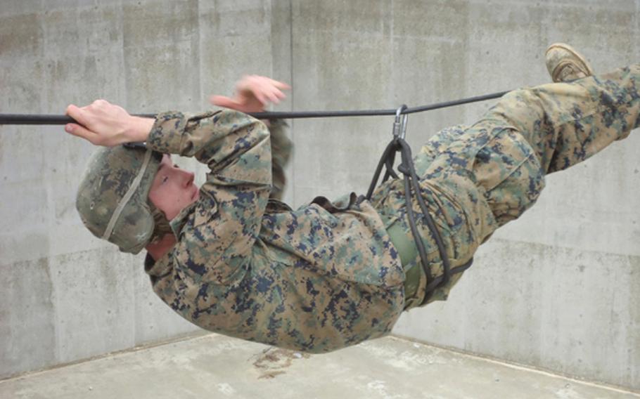 Lance Cpl. John Brooks Jr., pulls himself over an empty concrete pool during a ropes course at the Jungle Warfare Training Center in March.
