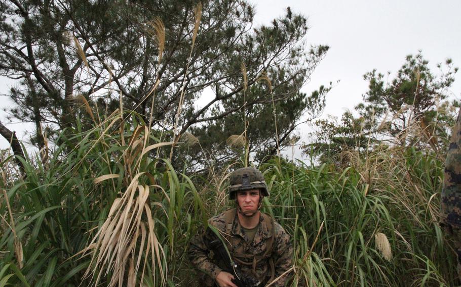 Lance Cpl. James Spooner emerges from thick jungle undergrowth during a land-navigation exercise at the Okinawa Jungle Warfare Training Center in March.


