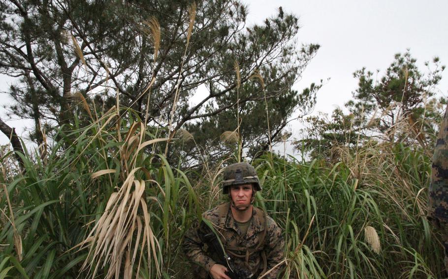 Lance Cpl. James Spooner emerges from thick jungle undergrowth during a land-navigation exercise at the Okinawa Jungle Warfare Training Center in March.