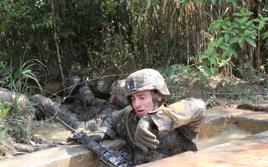 Lance Cpl. Jake Bombrys jumps into a concrete pool, filled with putrid jungle water, and covered with plywood. With barely enough room to breath, the 3rd Platoon Marine had to traverse underwater obstacles. The obstacle is part of the Jungle Warfare Training Center's E-Course.
