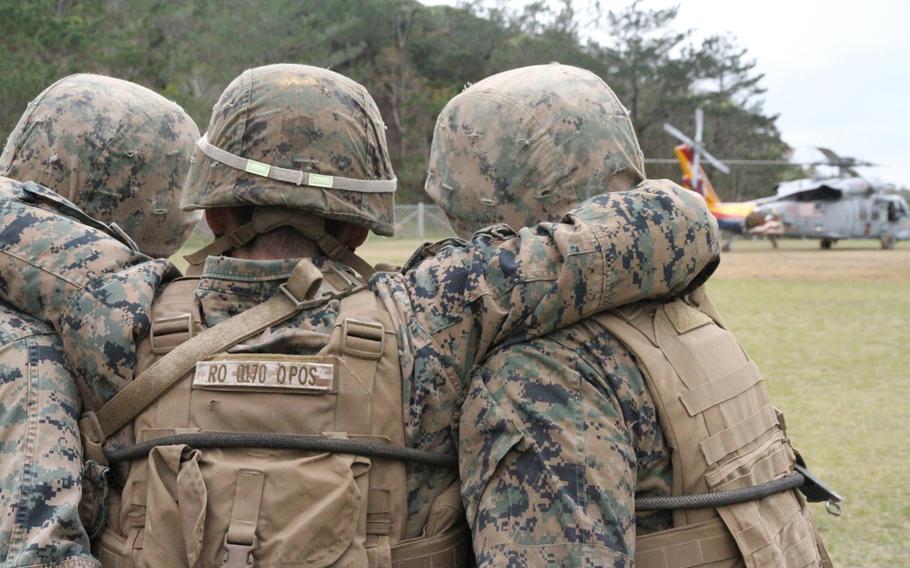 A Marine feigning an injury is carried to a waiting MH-60S helicopter from Helicopter Sea Combat Squadron 12 during casualty evacuation drills at Okinawa's Jungle Warfare Training Center in March 2015.

