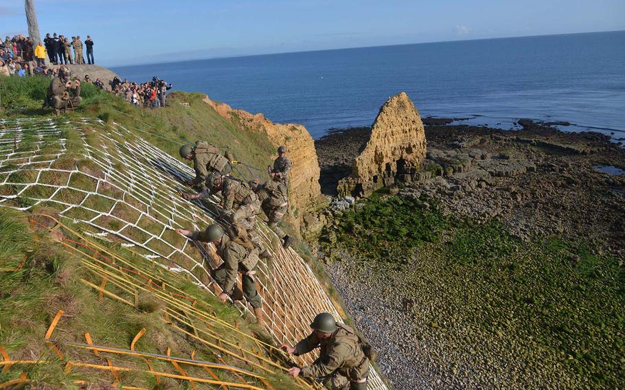 Soldiers of the 75th Ranger Regiment climb up the 100-foot cliffs of Pointe du Hoc on the Normandy coast, much like their counterparts did on D-Day, 75 years ago. In the background at left is the Ranger Monument.