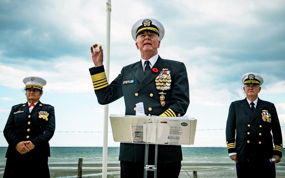 Adm. James Foggo, commander, U.S. Naval Forces Europe and Africa, holds sand from Utah beach in Normandy, France, as he delivers remarks during a dedication ceremony for a Lone Sailor monument on June 6, 2019. The sand came from Foggo's father who took part in the Normandy invasion as a member of the Canadian forces. 