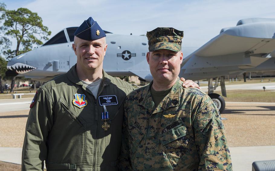 U.S. Air Force Maj. Jeremiah "Bull" Parvin, 75th Fighter Squadron director of operations, and U.S. Marine Corps Master Gunnery Sgt. Richard Wells, senior enlisted adviser of Marine Special Operations School, pose for a photo Jan. 29, 2015, at Moody Air Force Base, Ga. Parvin received the Distinguished Flying Cross with Valor for his heroic actions that saved the lives of Wells' team during a 2008 deployment to Afghanistan.