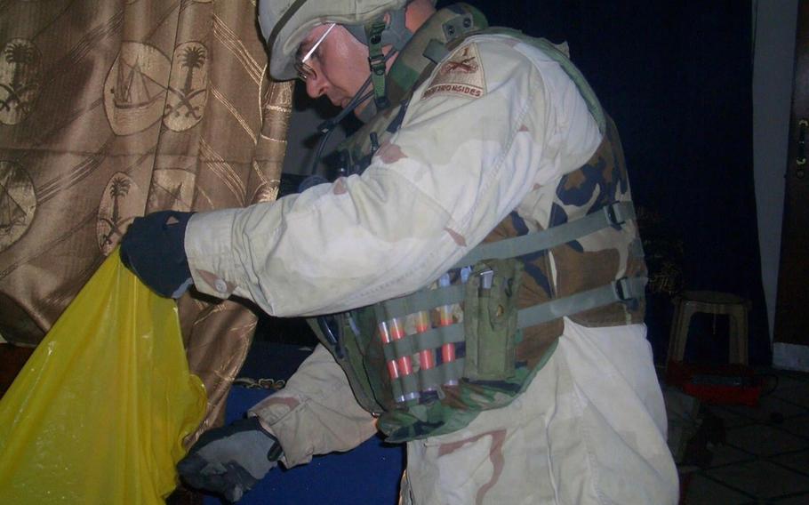 Jeff Hall searches a house in Iraq during his first deployment there in 2003. Hall retired last year as a Major, after a 20-year Army career.