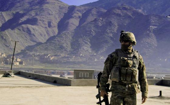 Pfc. Sean T. Ambriz, a military policeman with the 984th Military Police Company, stands on a rooftop in the mountains of eastern Afghanistan during his first deployment to the country in 2009.