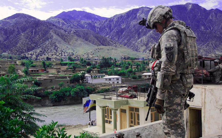 Pfc. Sean T. Ambriz looks down from his rooftop position in Kunar province in eastern Afghanistan.